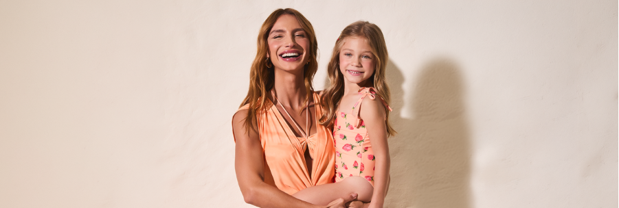 mujer con vestido naranja y niña usando un enterizo estampado